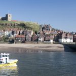 View across the harbour and River Esk to St Mary's Church in Whitby on top of Tate Hill on the Yorkshire coast